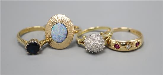 Three 18ct gold dress rings: diamond cluster, size K, ruby and diamond three stone, size O and synthetic sapphire, size L, and an opal